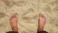 Men`s Legs on the sea sand and wave, Relaxation on the ocean beach, Summer holidays.