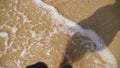 Men`s Legs on the sea sand and wave, Relaxation on the ocean beach, Summer holidays.