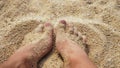 Men`s Legs on the sea sand and wave, Relaxation on the ocean beach, Summer holidays.