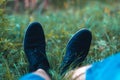 Men`s legs in sneakers in the park on the grass.