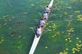 Men`s quadruple rowing team on green water