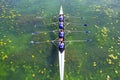 Men`s quadruple rowing team on green water