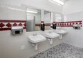 The sinks in a clean, tiled, modern Men`s room. Royalty Free Stock Photo