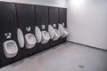 Men's room with white porcelain urinals in line. Modern clean public toilets with tiles . Comfort male toilet urinal Royalty Free Stock Photo