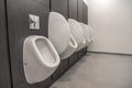 Men's room with white porcelain urinals in line. Modern clean public toilets with tiles . Comfort male toilet urinal Royalty Free Stock Photo