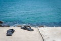 Men`s sandals on the concrete promenade by the sea Royalty Free Stock Photo