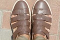 Men`s sandals on the leg are close-up brown with shortened trousers Royalty Free Stock Photo