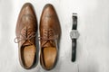 Men`s set for the wedding: brown leather patent-leather boots and silver wrist watch with black strap Royalty Free Stock Photo