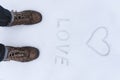 Men's shoe close up view with love simbol wrtien on the snow