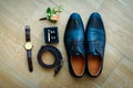 Men`s shoes in black leather, close-up. Wedding concept. Men`s shoes, cufflinks, belt, watch and boutonniere, top view