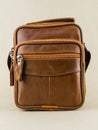 Men`s small brown leather bag is on the table