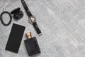 Men's watches, glasses, smartphone, accessories. Black accessories on a gray background
