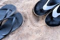 Men& x27;s and women& x27;s beach shoes on the sand under the rays of the sun. Royalty Free Stock Photo