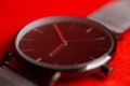 men's wristwatch close-up on a red background.