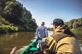 Men sailing on motor boat by river to the hunting camp during hunting season Royalty Free Stock Photo