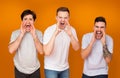 Men screaming loudly over orange studio background