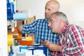 Men selecting roll film from shelf