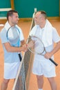 Men shaking hands over tennis court net Royalty Free Stock Photo