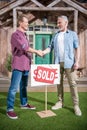 Men shaking hands with saleman and buying house Royalty Free Stock Photo