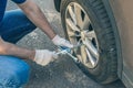 Men in a shirt and repair gloves using cross wrench tighten the bolts wheel of punctured wheel. Hole in the tire. Concept.