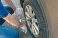 Men in a shirt and repair gloves using cross wrench tighten the bolts wheel of punctured wheel. Hole in the tire. Concept.