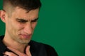 Men are showing chest pain. Close-up portrait of a funny crying man emotions of a handsome man guy on a green background Royalty Free Stock Photo