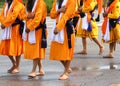 men of Sikh Religion with long orange clothes walk barefoot