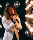Men singer with long hair, with microphone on the stage Royalty Free Stock Photo