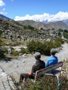 Two Men Sitting on a Bench Overlooking Muktinath Valley, Nepal Royalty Free Stock Photo