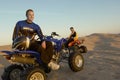Men Sitting On Quadbikes In Desert Royalty Free Stock Photo