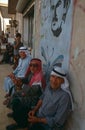 Men sitting under a picture of Hafez Al'Assad, Syria