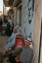 Men sitting under a picture of Hafez Al'Assad, Syria