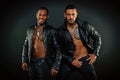 Men on smiling faces with bristle. Leather masculine clothing concept. Machos with muscular torsos look attractive in Royalty Free Stock Photo
