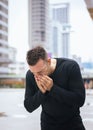 Man sneeze on street because pollution,Male got nose allergy on street Royalty Free Stock Photo