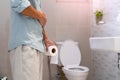 Men are standing in front of the bathroom door using their hands to hold the abdomen with severe abdominal pain or diarrhea. The c