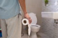 Men are standing in front of the bathroom door using their hands to hold the abdomen with severe abdominal pain or diarrhea. The c