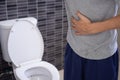 Men are standing in front of the bathroom door using their hands to hold the abdomen with severe abdominal pain or diarrhea. The c