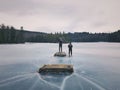 Men standing on frozen lake