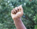 Men strong fist hand stretching up on soft green bokeh background