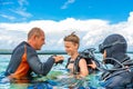 A man in a suit for diving prepares a boy to dive Royalty Free Stock Photo