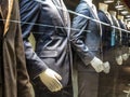 Men Suits, with shirts, ties, pants and blue jackets on display on dummies in front of a tailor store, on a window. Royalty Free Stock Photo