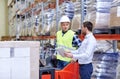 Men with tablet pc and forklift at warehouse Royalty Free Stock Photo