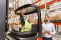 Men with tablet pc and forklift at warehouse Royalty Free Stock Photo
