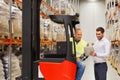 Men with tablet pc and forklift at warehouse Royalty Free Stock Photo