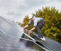 Men technicians mounting photovoltaic solar moduls on roof of house. Royalty Free Stock Photo