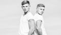 Men twins brothers muscular guys in white shirts sky background. Brotherhood concept. Benefits of having twin brother Royalty Free Stock Photo