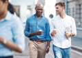 Men, walk and street with takeaway coffee while talk, smile and relax at lunch break. Black man, colleague and diversity Royalty Free Stock Photo