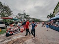 men walking past a couple of people at an outdoor market