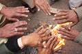 Men warm hands over the fire in India