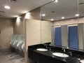 Men wash room or toilet having wash basin granite finished counter cubicles urinals beveled mirrors and partitions